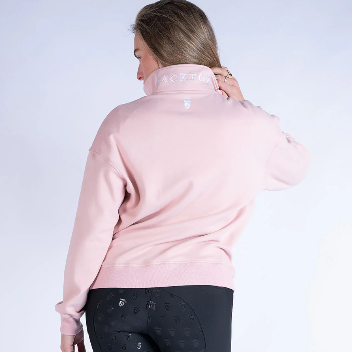 person wearing a pink sweater with BLACKFORT embroidered logo on a grey background