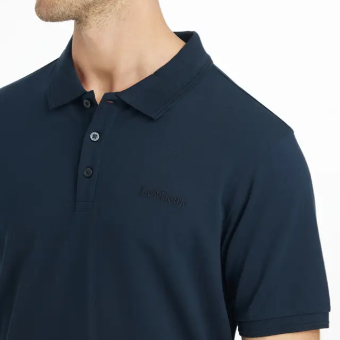 Man wears a navy blue polo t-shirt on a white background