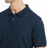 Man wears a navy blue polo t-shirt on a white background