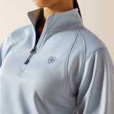 Light blue pullover with a brand logo on a neutral background