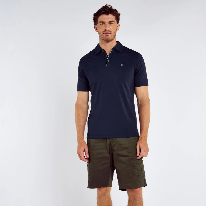 Man wearing a navy polo shirt and shorts on a white background