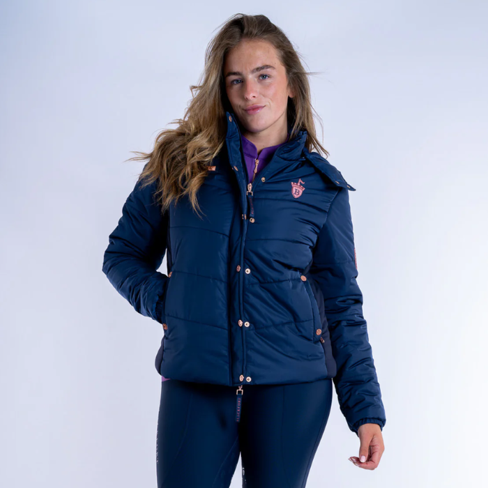 Person wearing a blue jacket with a logo on a white background