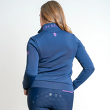 Woman wears a blue sweaer with purple branding detail on a grey background