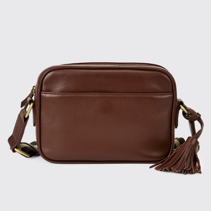 Brown leather crossbody bag with tassel on a light grey background