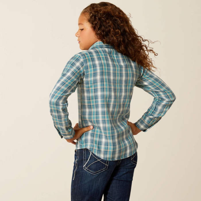 Person wearing a blue plaid shirt and jeans on a beige background
