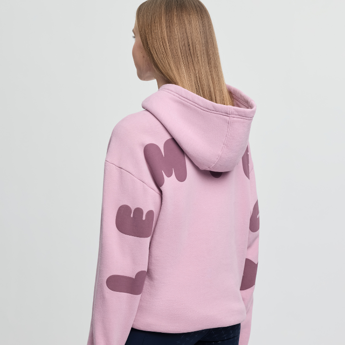 Person wearing a pink hoodie with abstract design on a plain background