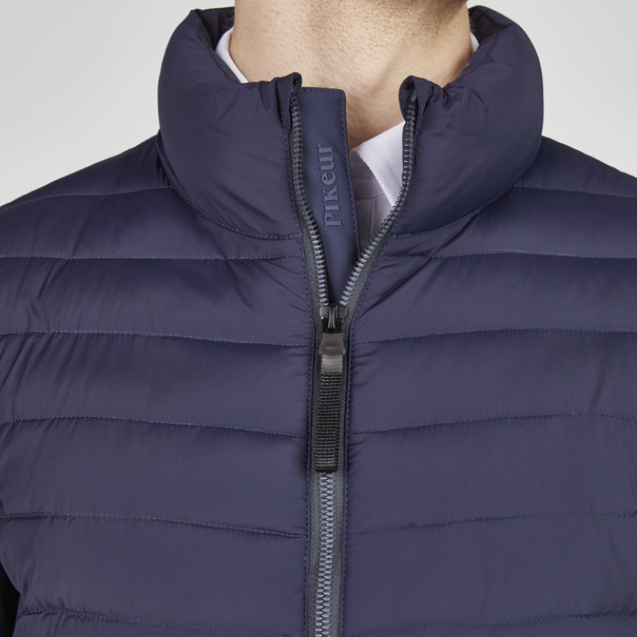 Navy puffer jacket with a zipper, featuring the brand 'Pikeur', on a neutral background.