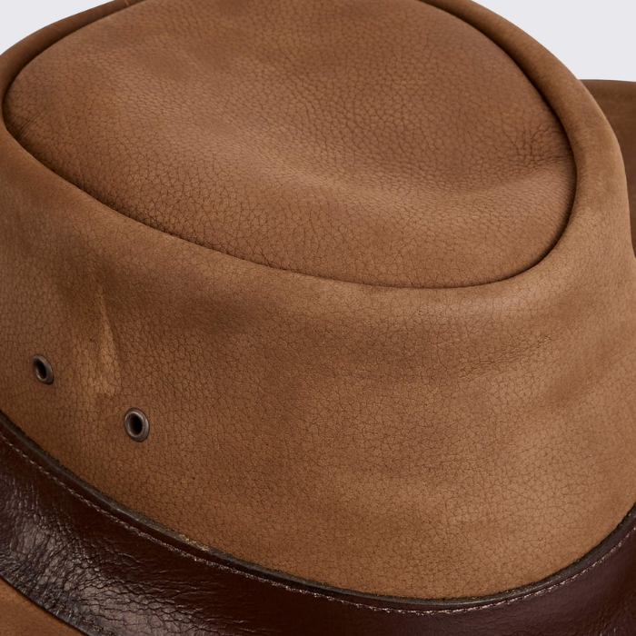 Close-up of a brown leather hat with a textured surface.