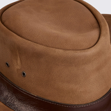 Close-up of a brown leather hat with a textured surface.