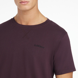 Close-up of a purple t-shirt and black LeMieux branding on a white background