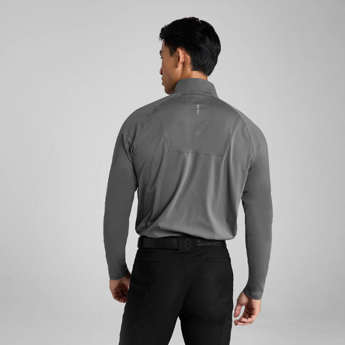 Man wearing a grey long-sleeve shirt and black breeches on a light grey background