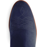 Embroidered detail on the of a blue suede boot on a white background
