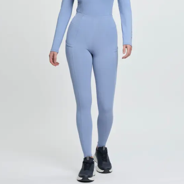 Blue riding leggings with black trainers on a grey background