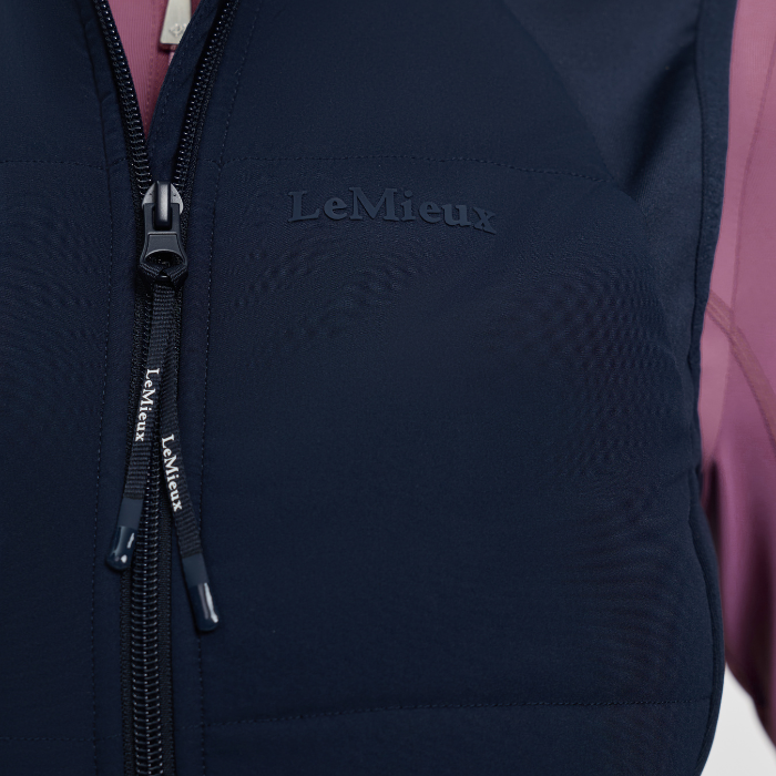 Navy blue equestrian gilet with 'LeMieux' branding on a close-up of the zipper.