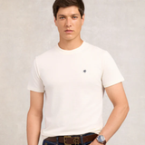 Man wearing a white t-shirt with a small HC logo on a plain background