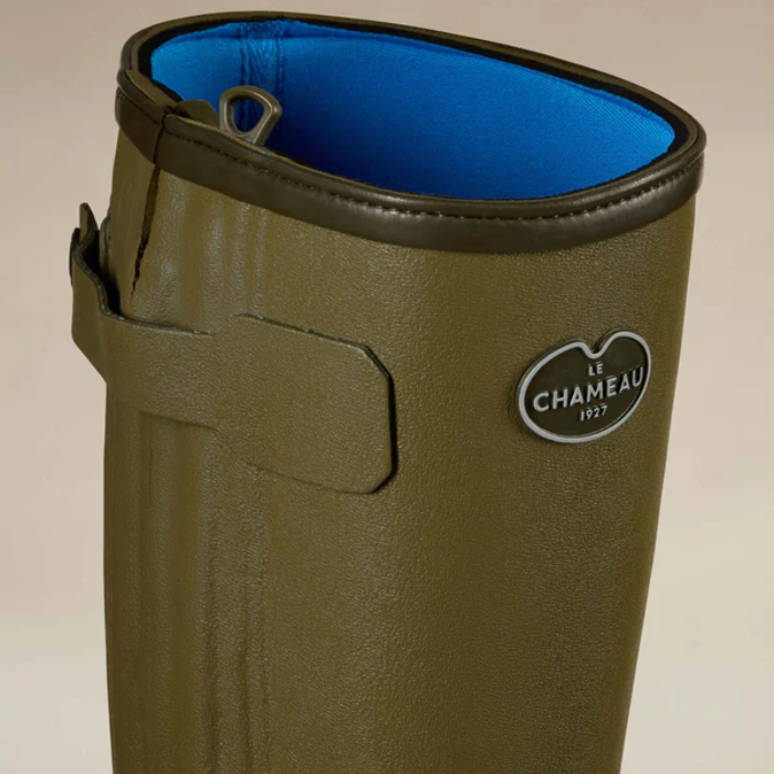 Close-up of a green wellington boots with a blue neoprene lining on a neutral background