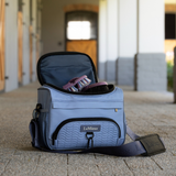 Blue equestrian bag with a strap on a stone floor, featuring the LeMieux brand.