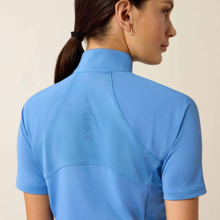 Woman wearing a blue short-sleeve shirt with a neutral background