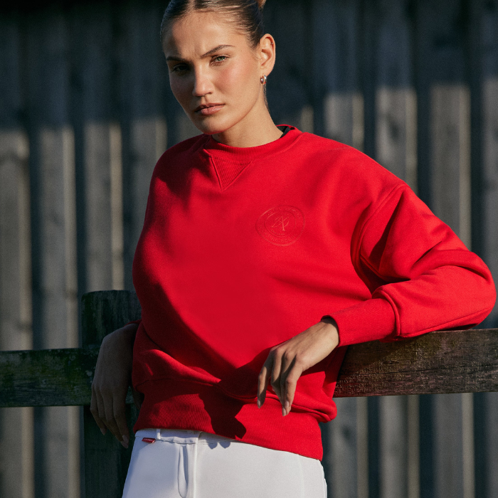 Woman wears a red sweatshirt in an outdoor setting