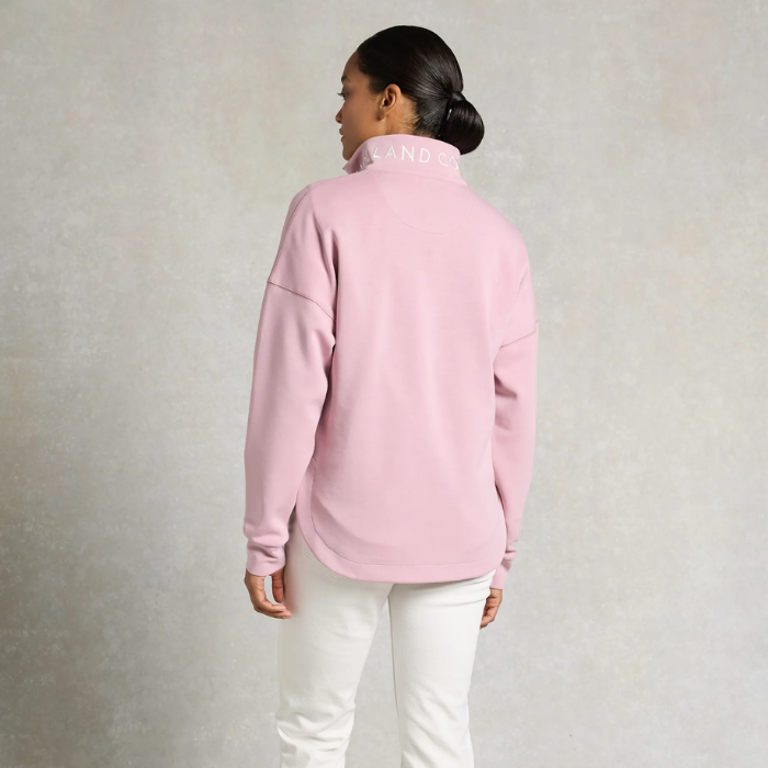 Pink quarter zip sweatshirt on a white background with white jeans