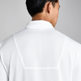 Person wearing a white polo shirt with a plain background