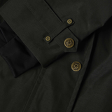 Close-up of a dark green coat with brass buttons on a dark background