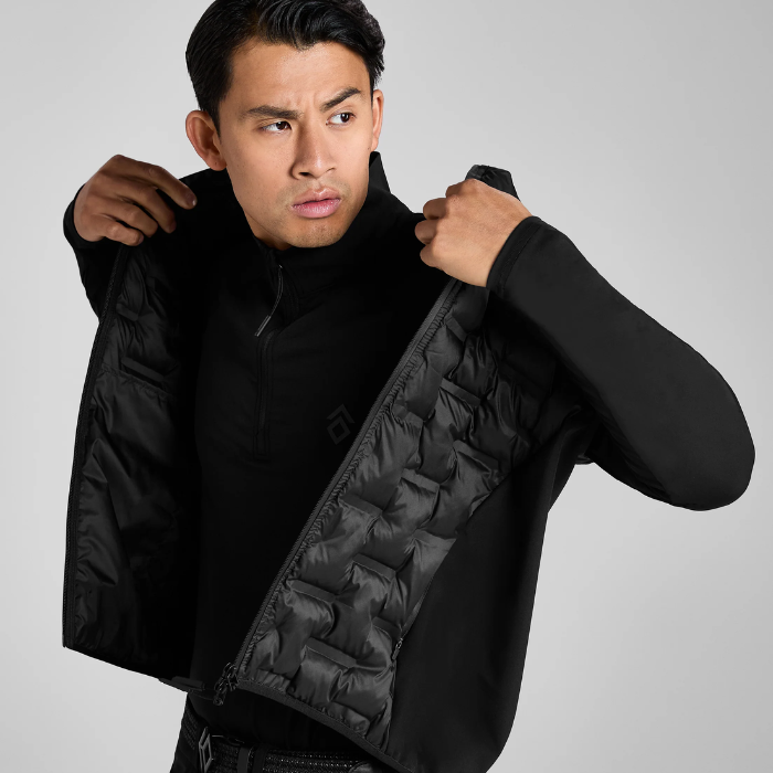 Man wearing a black long sleeve top and gilet on a grey background