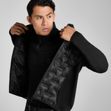 Man wearing a black long sleeve top and gilet on a grey background