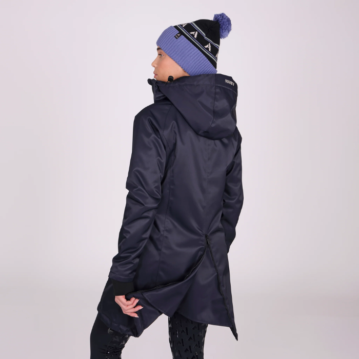Person wearing a dark winter coat and a matching beanie on a light grey background