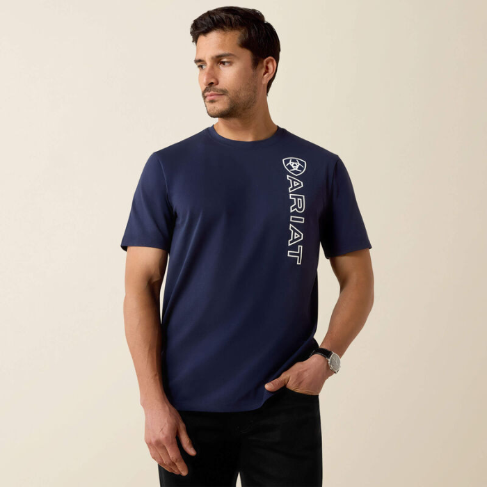 Man wearing a navy blue t-shirt with 'Ariat' logo on a beige background