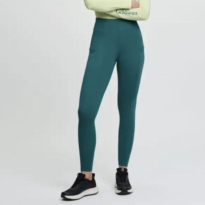 Teal leggings worn by a person on a light grey background