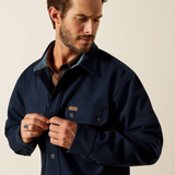 Man wearing a navy jacket against a beige background