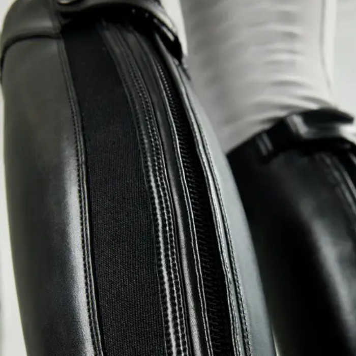Close-up of a black leather riding boot with a zipper