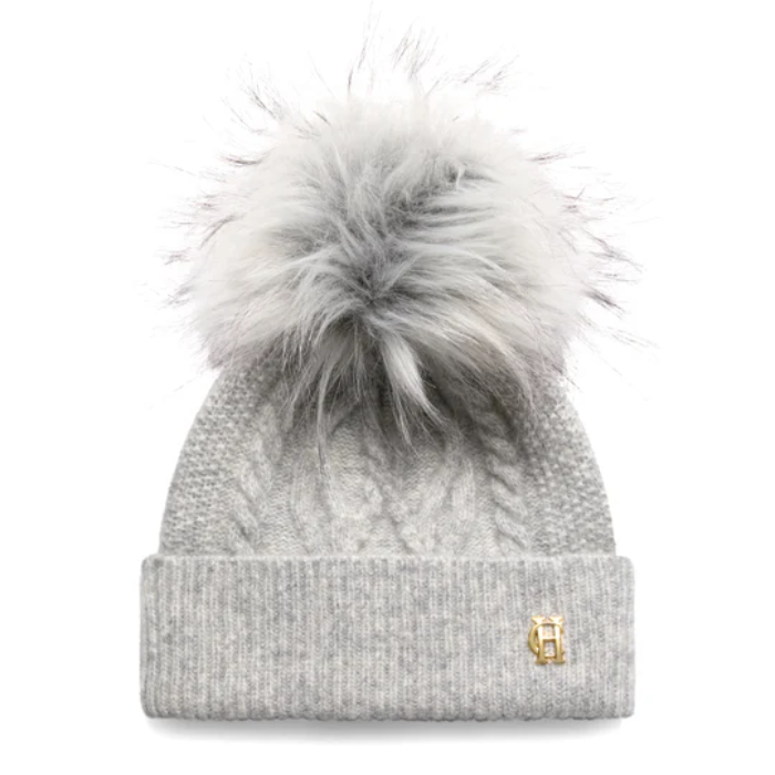 Grey knitted beanie hat with a fluffy bobble and gold HC hardware on a white background