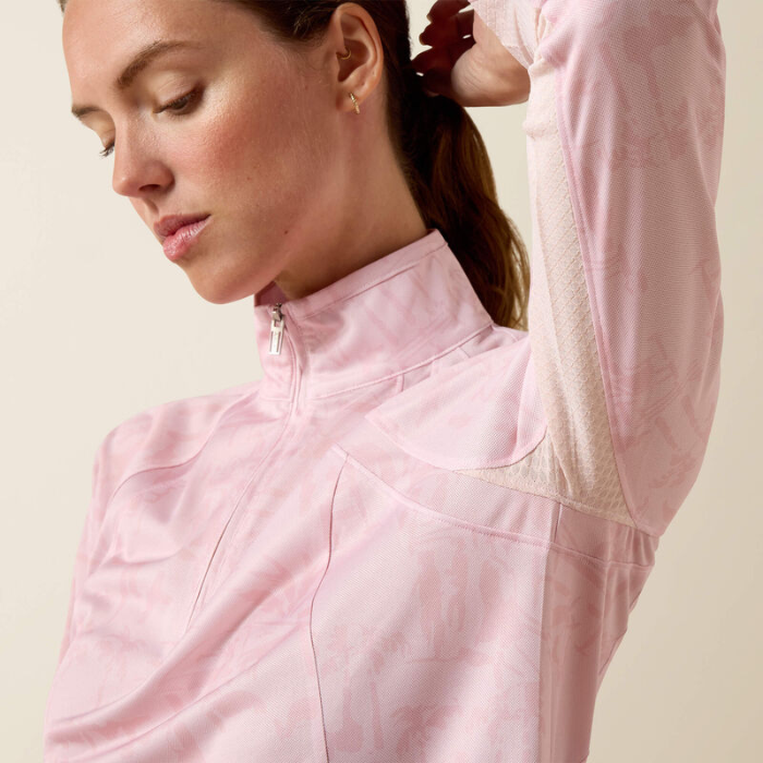 Woman wears a pink long sleeve top on a beige background