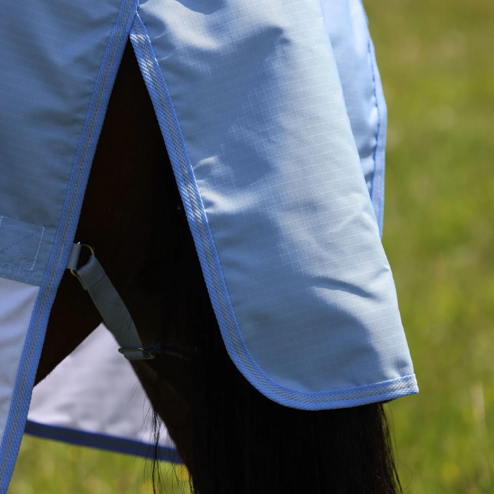 Blue tail guard on a horse fly rug with a blurred outdoor background