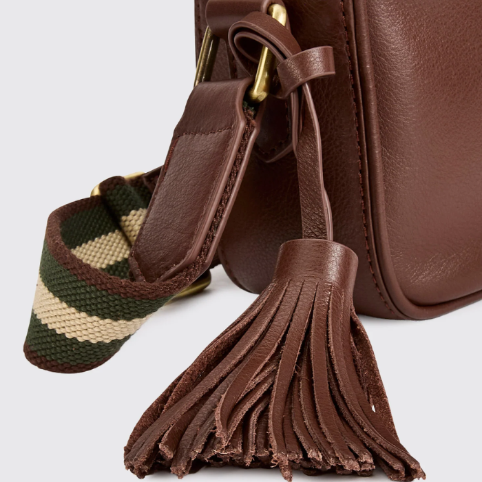 Brown leather handbag with a tassel detail on a white background