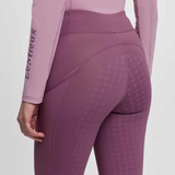 Pink riding leggings with pink top on a grey background