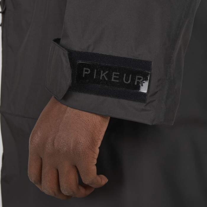 Close-up of a black jacket with 'PIKEUR' branding on the sleeve.