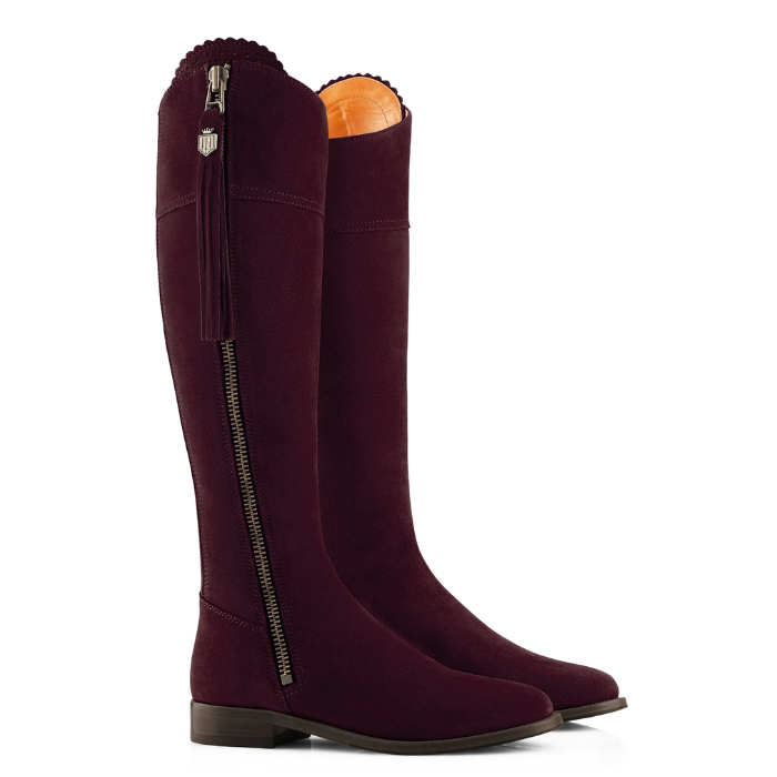 Pair of purple suede boots on a white background