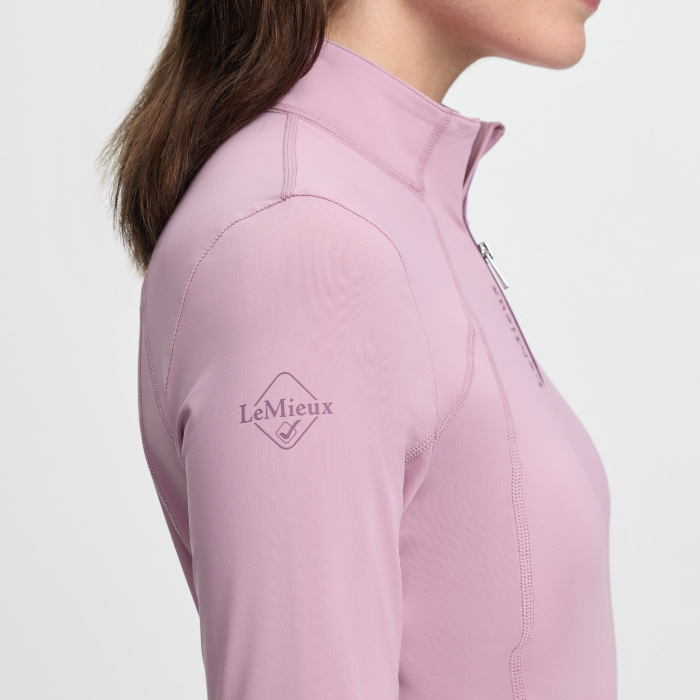 Close-up of a pink equestrian shirt with LeMieux logo on a white background