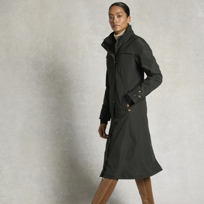 Woman wearing a dark coat against a neutral background