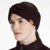 Woman wearing a brown knitted headband with a visible brand logo on a white background