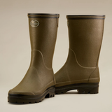 Pair of green rubber boots on a beige background