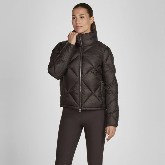 Woman wearing a dark brown quilted jacket on a light grey background