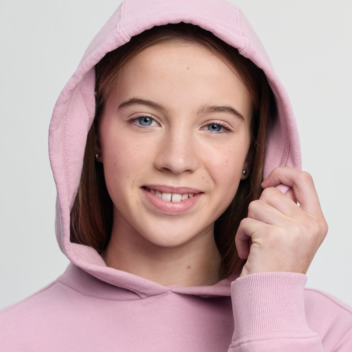 Person wearing a pink hoodie against a light grey background