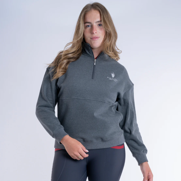 Woman wears a grey sweatshirt on a light background