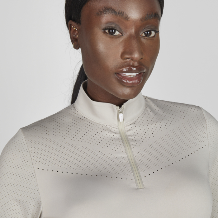 Woman wearing a light grey athletic shirt with a zipper on a white background