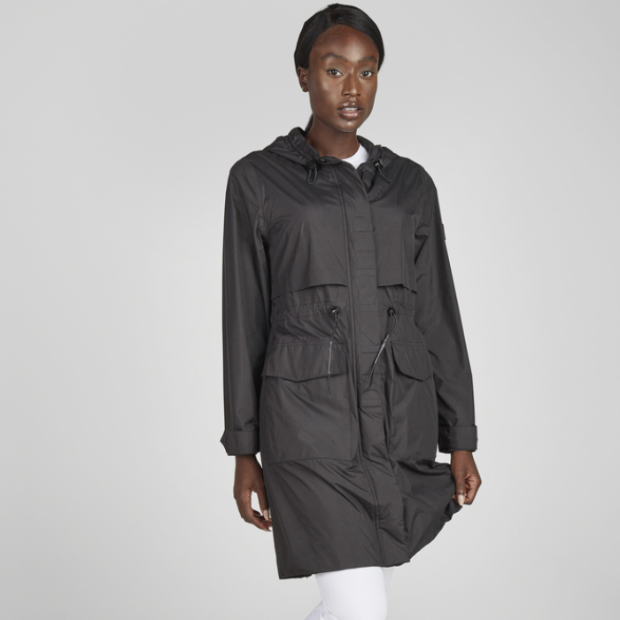 Person wearing a black hooded jacket on a grey background
