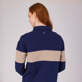 Person wearing a navy and beige striped polo shirt with a logo on the chest.